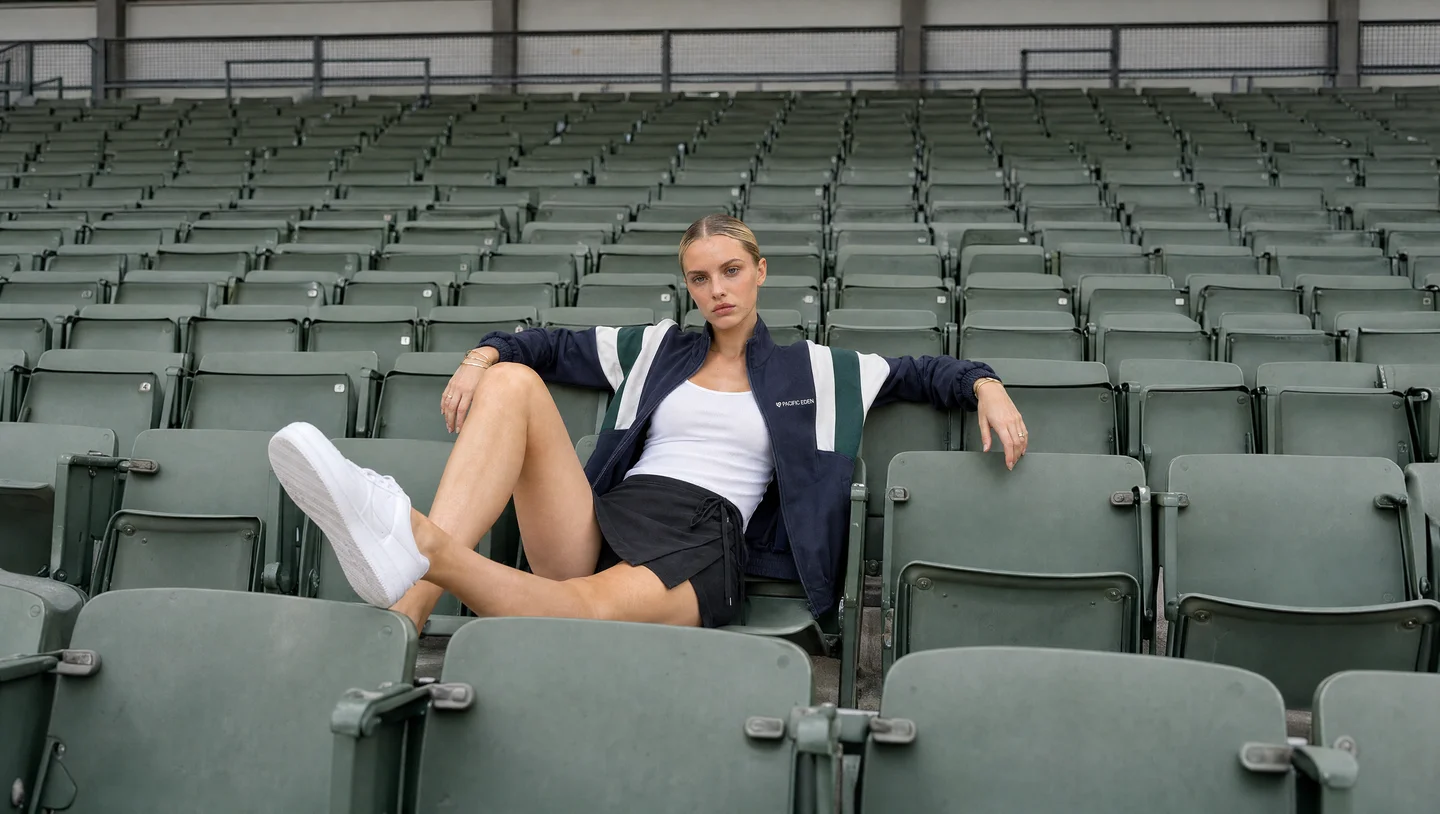 Generated campaign image of the model and outfit in a stadium.